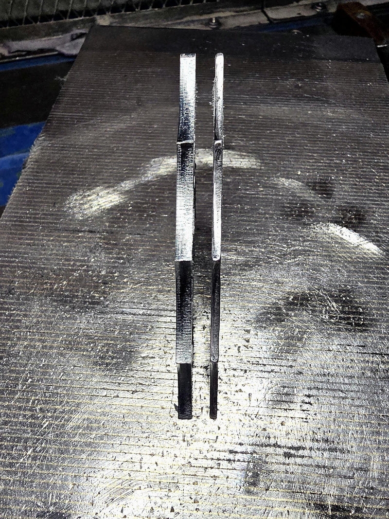 Side profile view showing the thickness and high-quality edge cut of two spider web steel corner gussets.