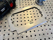 Metal pegboard tray on a perforated metal surface with a Husky tool in the background