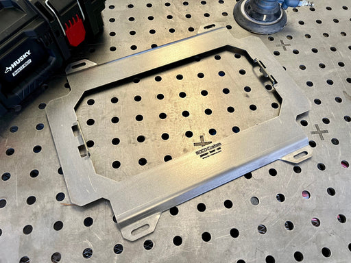 Metal pegboard tray on a perforated metal surface with a Husky tool in the background