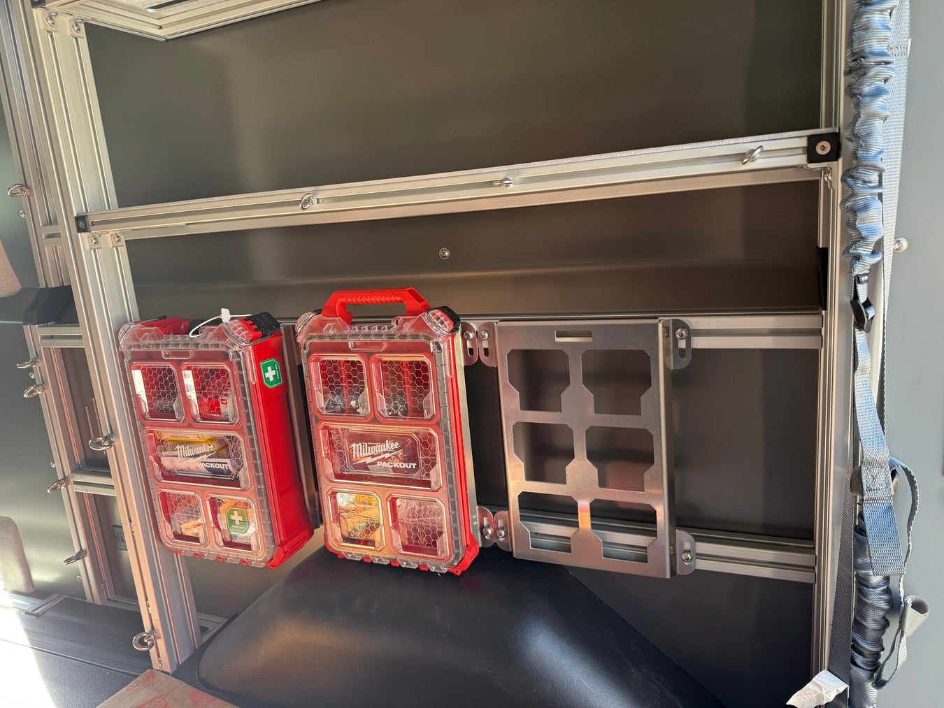 Lightweight aluminum Packout plate mounted to a track or rail in a work van, a rust-proof solution for utility trucks and trailers.