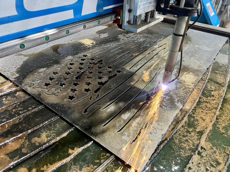 CNC machine cutting metal with sparks on a workbench