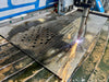 CNC machine cutting metal with sparks on a workbench