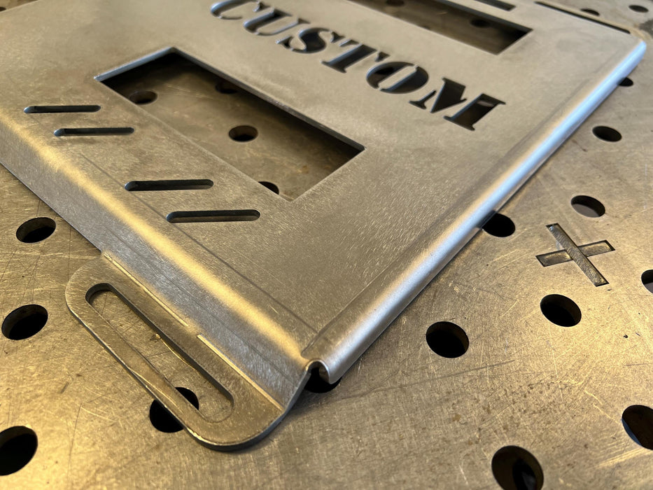 mounting plate for klein, raw steel with lightning bolt cut-out design, mounting hole close up