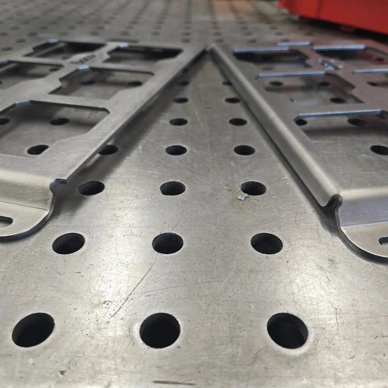 Bent edge and unbent edge of two B-Grade Packout mounting plates side by side