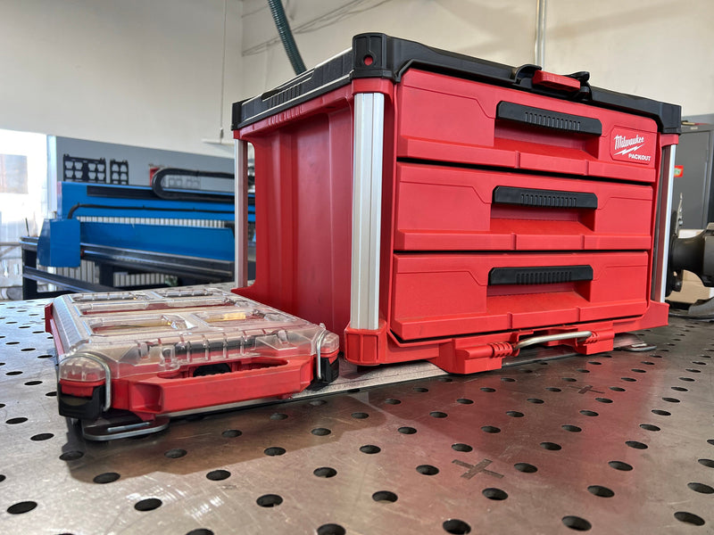 Red toolbox with multiple drawers on a metal workbench