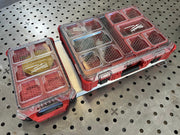Two red and clear tool organizers on a metal pegboard background